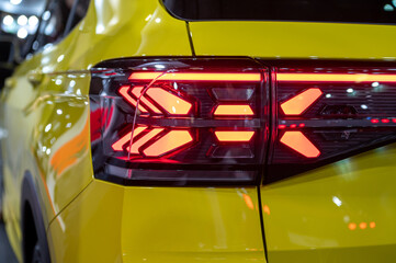 closeup of a red taillight on a modern car, detail on the rear light of a car - obrazy, fototapety, plakaty
