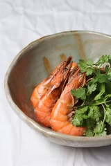 Boiled shrimp with soy sauce and coriander in a white bowl