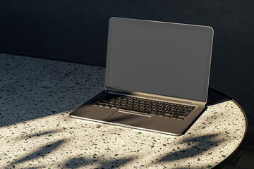 Close up of modern designer desktop with empty mock up laptop on marble desk, sunlight and shadows. 3D Rendering.