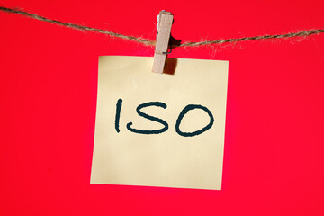The concept of ISO quality control certification approval. Abbreviation ISO It is written on a yellow sticker on a red background