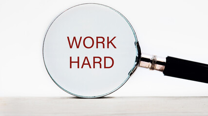 Work Hard text appeared through a magnifying glass on a white background