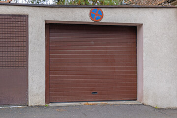 Closed Brown Garage Roll Door With No Parking Road Sign
