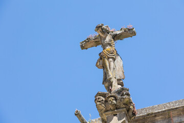 Fototapeta na wymiar A close-up of a weathered Jesus Christ statue on a cross with intricate details and sky in the background, capturing the essence of faith and history