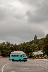 Fototapeta premium A blue van maneuvers through a winding road under the sky