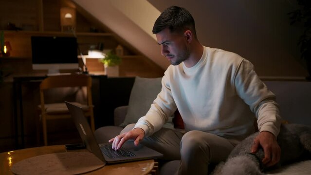Man with his dog working using a laptop at evening home