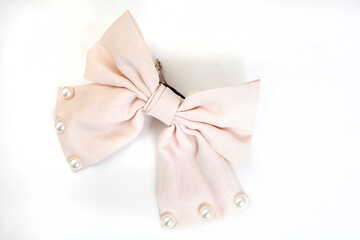 Cream colored hair bow with pearly detail isolated on white