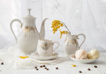 Modern still life with a coffee set and a spring mimosa branch on a light windowsill