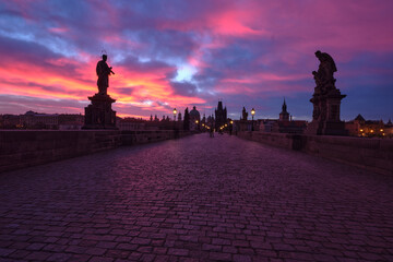 Charles Bridge at dawn, saint sculptures with street lights in Prague, Czech Republic