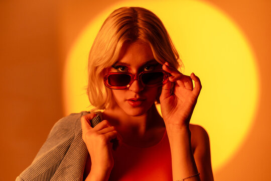 Sunglasses wearing model posing under bright light