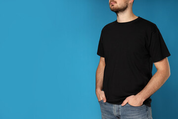 A young guy in a black t-shirt on a blue background