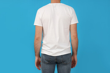 A young guy in a white t-shirt on a blue background