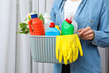 A basket with detergents in the hands of a woman