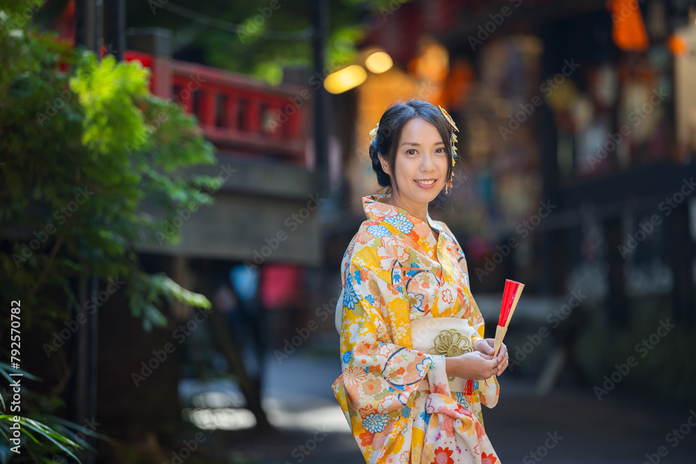 Canvas Prints asian woman try to wear japanese kimono with the traditional japanese village background