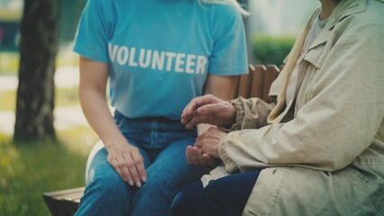 Close-up of volunteer taking homeless person by hand, social support, kindness