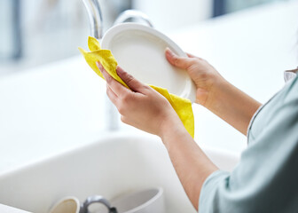 Kitchen, washing dishes or person with plate, hands and cloth cleaning in sink or basin in healthy...