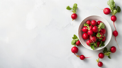 Spring red radishes in a bowl on a white table, aerial view, space on the left