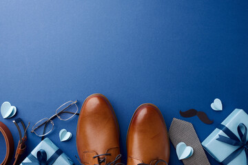Arrangement of Father's Day gifts, including leather shoes and heart shapes on a blue backdrop,...