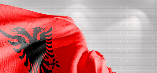 Albania national flag cloth fabric waving on beautiful bricks Background.	
