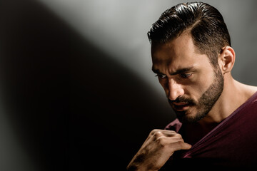 Portrait of self confident brutal minded man on dark dramatic background, Intensely strong: A...
