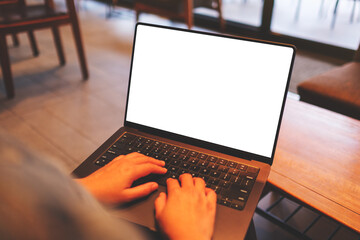 Mockup image of a woman using and typing on laptop computer with blank white desktop screen in cafe - 792601987