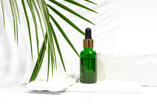 Cosmetic Serum Bottle with Palm Leaf on White background