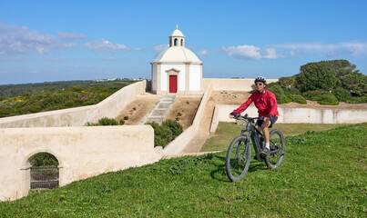 woman with electric mountain bike at Santuário de Nossa Senhora do Cabo Espichel, a famous...