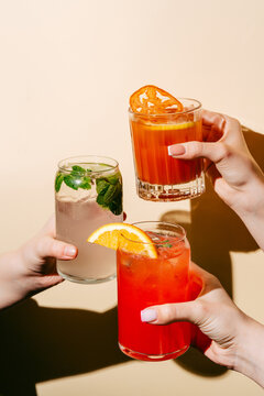 Anonymous trio of Refreshing Cocktails Held by Friends