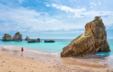 Woman walking at the stunning beach of the Praia do Ribeiro do Cac´valo, maybe the must beautiful...