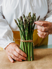 Close up of elderly woman's hands with asparagus