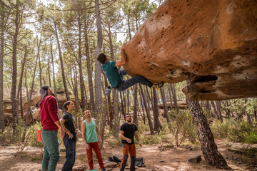 Group of friends practicing bouldering in the pine forest of Albarracin. © Alejandro Vicente
