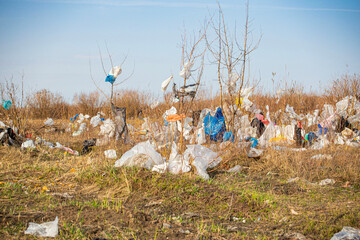 a dump and trash heap of plastic bags scattered across the field and trees, foreshadowing an...