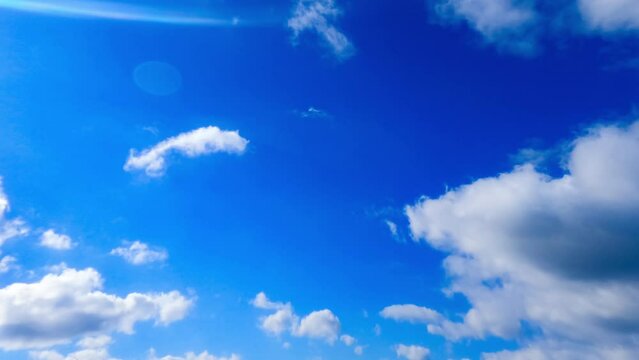 Amazing azure sky with small clouds quickly floating in the wind. Low angle perspective on summer sky. Timelapse.