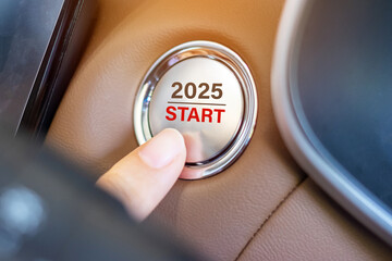 Finger press a car ignition button with 2025 START text inside  automobile. New Year New You,...