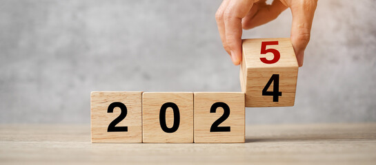 hand flipping block 2024 to 2025  text on table. Resolution, strategy, plan, goal, motivation,...