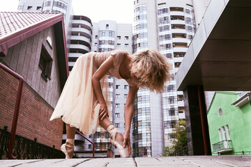 ballerina on pointe poses on a summer day on the street showing elements of ballet