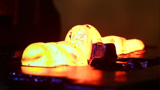 metal forging. metal piece shaping. automatic drop hammer giving it a tool shape. Open die forging. metal hit by a hammer on a mould cast machine tool component part. weld factory blurry