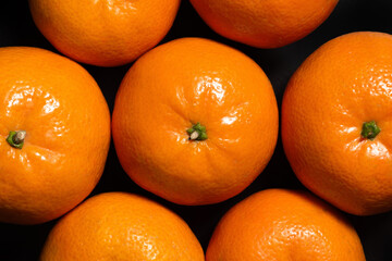 Fresh tangerines on a black background, top view. Food background - 792633997