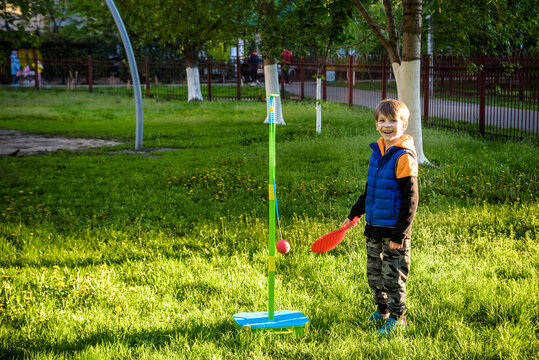 Happy boy is playing tetherball swing ball game in summer camping. Happy leisure healthy active time outdoors concept