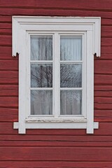 Closeup of window on a traditionally red painted wall.