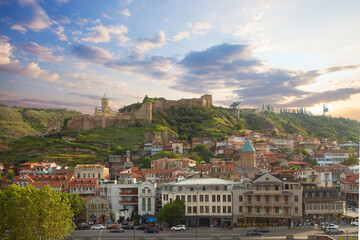 Beautiful landscape of Tbilisi on the background of blue cloudy sky and green mountains - obrazy, fototapety, plakaty