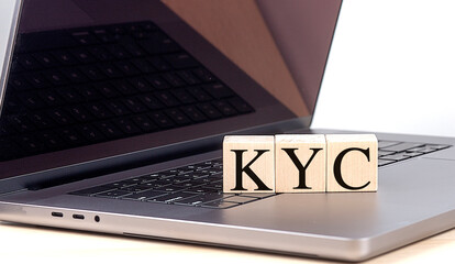 KYC word on wooden block on laptop , business concept