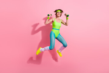 Photo of positive sporty coach lady jump training with dumbbells isolated over pastel color background