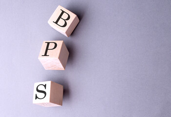 BPS word on wooden block on gray background