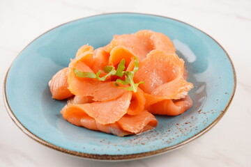 Smoked salmon on a blue plate on the white background
