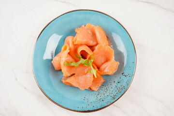 Smoked salmon on a blue plate on the white background