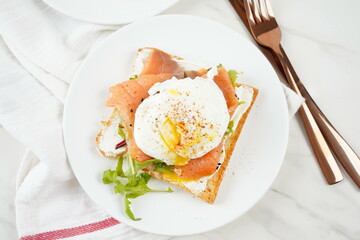 Eggs Benedict with smoked salmon, herbs, and hollandaise sauce