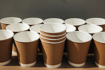 A set of paper utensils, cups on a brown background. Eco friendly, zero waste concept. Front view