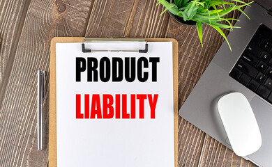 PRODUCT LIABILITY text on clipboard paper with laptop, mouse and pen
