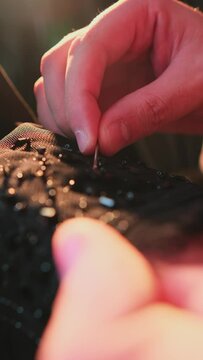 A master sews national Arab clothes abay with a needle and thread in his atelier