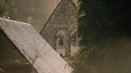 Old small church bells in sunny rain slow motion